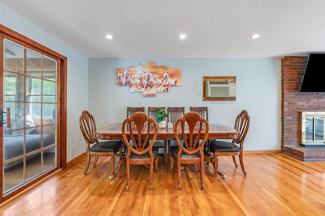 dining area featuring baseboards, a wall unit AC, light wood-type flooring, and recessed lighting