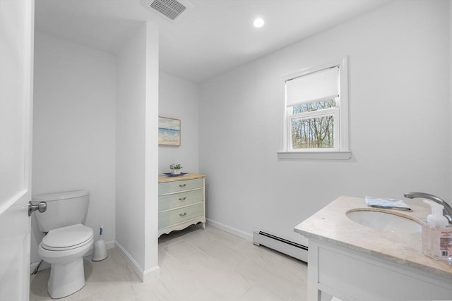 bathroom featuring a baseboard heating unit, vanity, toilet, baseboards, and recessed lighting