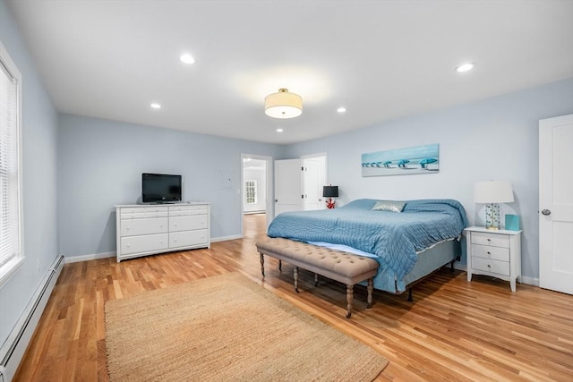 bedroom featuring a baseboard heating unit, light wood-style flooring, baseboards, and recessed lighting