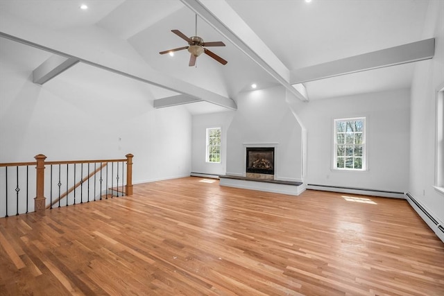 unfurnished living room with healthy amount of natural light, a baseboard heating unit, light wood finished floors, ceiling fan, and recessed lighting