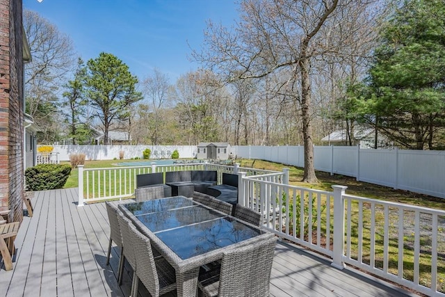 wooden terrace with an outdoor structure, a storage shed, and outdoor dining space