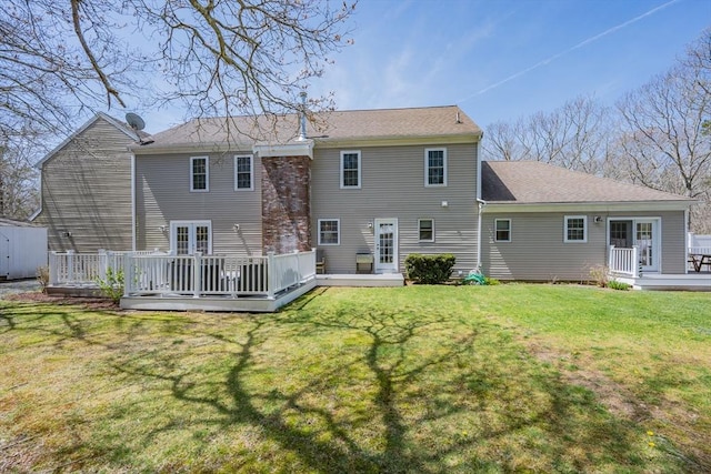 back of house featuring a wooden deck and a yard