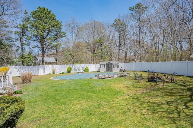 view of yard with a fire pit, a storage unit, and an outdoor structure