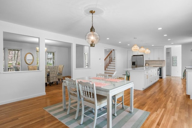 dining room featuring light wood-style flooring, stairway, recessed lighting, and baseboards