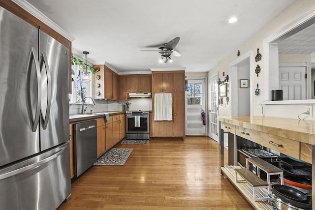 kitchen with sink, ceiling fan, stainless steel appliances, dark hardwood / wood-style flooring, and decorative light fixtures