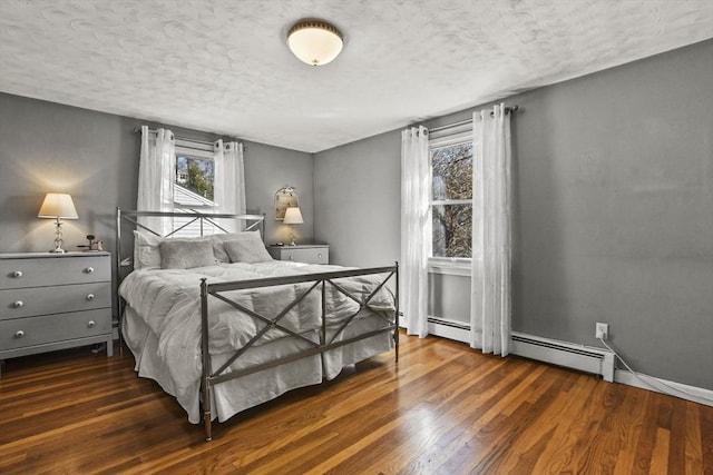 bedroom with a baseboard radiator, dark hardwood / wood-style floors, and a textured ceiling