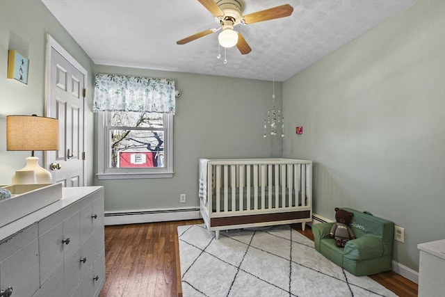 bedroom with baseboard heating, ceiling fan, and hardwood / wood-style flooring