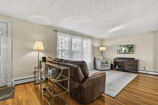 living room featuring hardwood / wood-style flooring, a baseboard radiator, and a textured ceiling