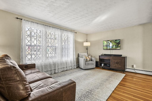 living room featuring hardwood / wood-style flooring, a textured ceiling, and baseboard heating