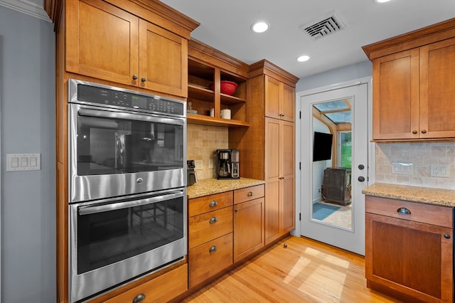 57 Hampton St, Auburn, MA 01501 - kitchen with stainless steel double oven, backsplash, brown cabinetry, and recessed lighting