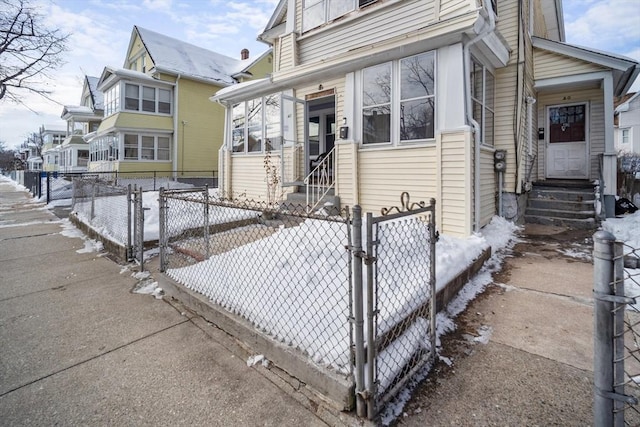 view of front of house with entry steps, a residential view, and fence private yard