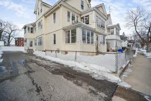 view of side of home featuring entry steps and fence