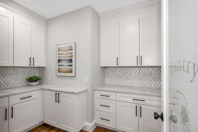 kitchen featuring white cabinetry, dark hardwood / wood-style flooring, light stone counters, and tasteful backsplash