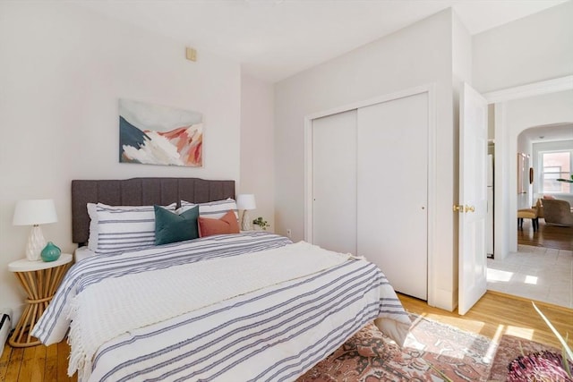 11 Revere Unit 4, Boston, MA 02114 - bedroom featuring light wood-style flooring, arched walkways, and a closet