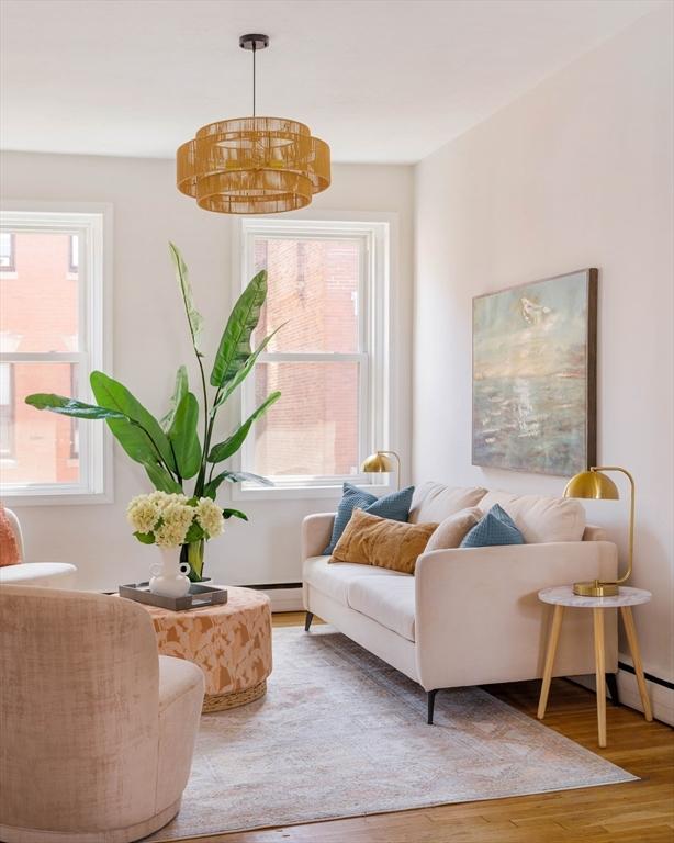 11 Revere Unit 4, Boston, MA 02114 - living area with wood finished floors, healthy amount of natural light, and a baseboard heating unit