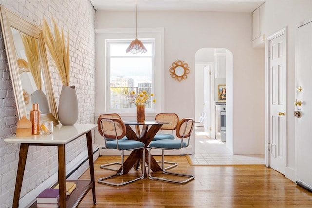 11 Revere Unit 4, Boston, MA 02114 - dining area featuring arched walkways, wood finished floors, and brick wall