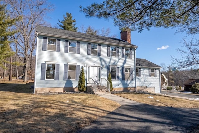 colonial house featuring a chimney