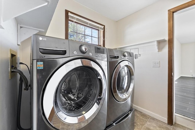 laundry area featuring laundry area, washing machine and dryer, and baseboards