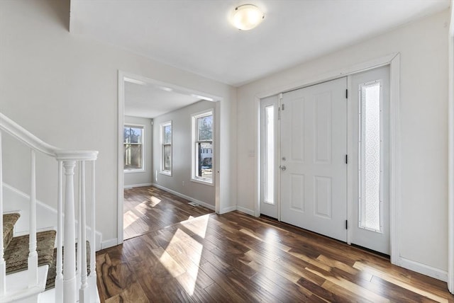 entrance foyer with stairs, wood finished floors, and baseboards