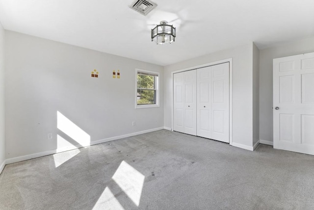 unfurnished bedroom with visible vents, baseboards, a closet, and carpet flooring