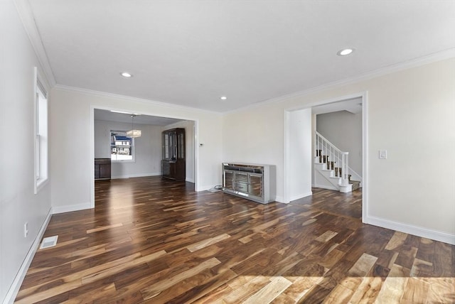 unfurnished living room with stairway, wood finished floors, visible vents, baseboards, and crown molding