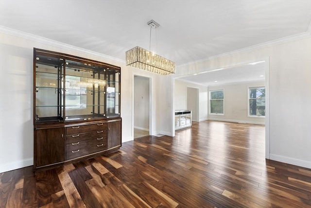 unfurnished dining area featuring baseboards, dark wood-type flooring, and ornamental molding