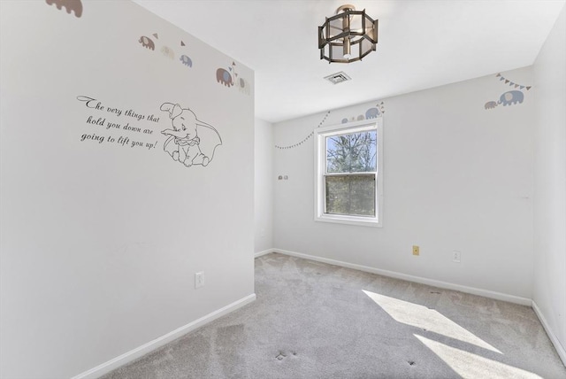 carpeted spare room with baseboards and visible vents