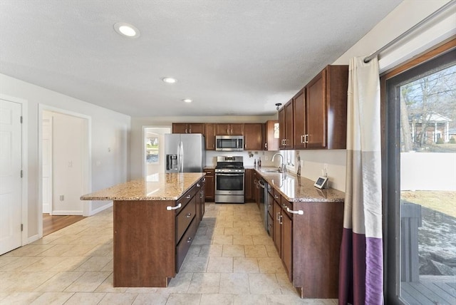 kitchen with a center island, plenty of natural light, appliances with stainless steel finishes, and a sink