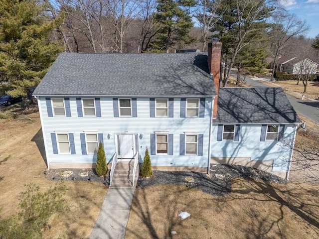 colonial-style house with a chimney and a shingled roof