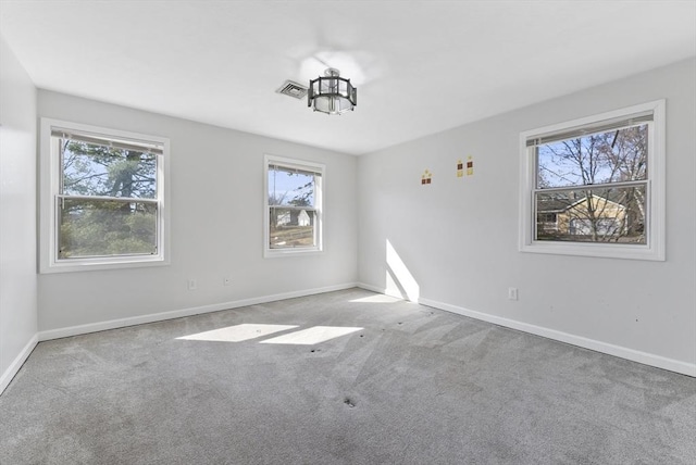 empty room featuring visible vents, baseboards, and carpet flooring