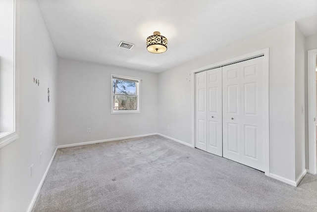 unfurnished bedroom with visible vents, carpet floors, baseboards, and a closet