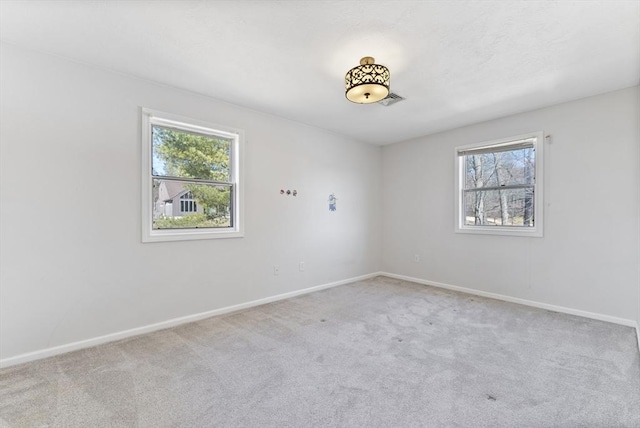 empty room featuring baseboards, carpet, and a healthy amount of sunlight