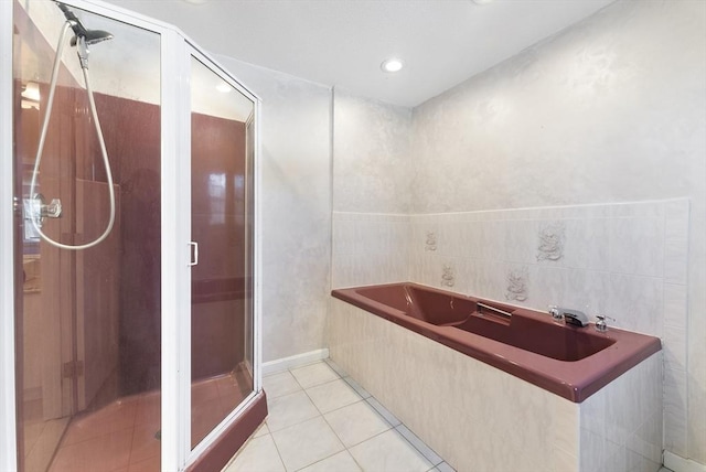 bathroom with a bath, a shower stall, and tile patterned flooring