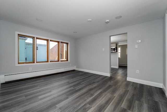 unfurnished room with dark wood-style flooring, baseboards, and baseboard heating