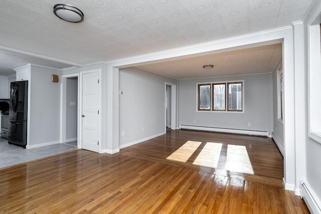 unfurnished living room featuring a baseboard radiator, wood finished floors, baseboards, ornamental molding, and baseboard heating