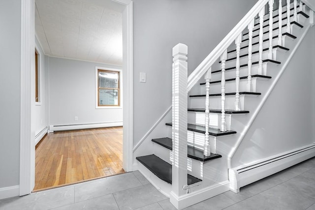 staircase featuring a baseboard radiator, tile patterned flooring, and baseboards