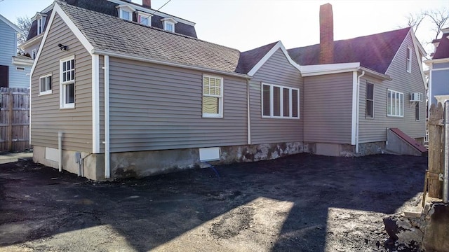 view of home's exterior featuring a chimney and fence