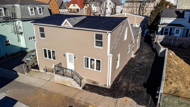 back of property featuring a residential view and fence