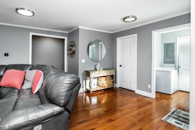 living room featuring ornamental molding, electric panel, baseboards, and wood finished floors