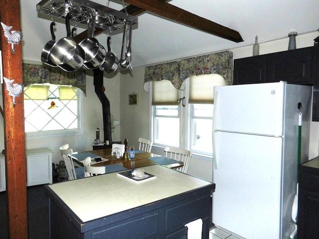 55A Millville Cir, Salem, NH 03079 - kitchen with freestanding refrigerator, plenty of natural light, a wood stove, and a kitchen island