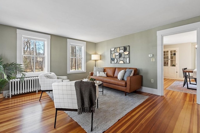 living room with light wood-style flooring, radiator, and baseboards