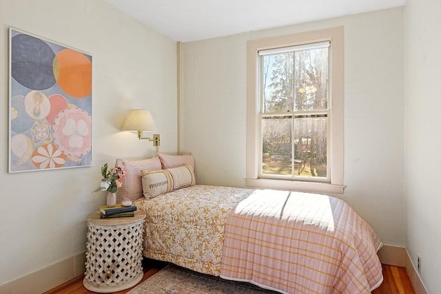 bedroom featuring baseboards and wood finished floors