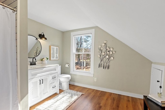 full bathroom with vanity, wood finished floors, baseboards, lofted ceiling, and toilet