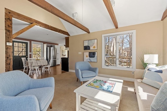 living area with baseboards, vaulted ceiling with beams, and carpet flooring