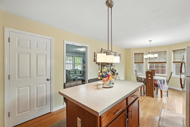 82 Lloyd Ave, Springfield, MA 01119 - kitchen with light wood-style flooring, brown cabinets, a center island, and freestanding refrigerator