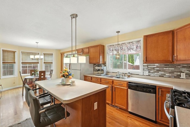 82 Lloyd Ave, Springfield, MA 01119 - kitchen with appliances with stainless steel finishes, a kitchen breakfast bar, light wood-style floors, and light countertops