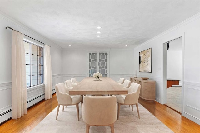 dining area featuring a wainscoted wall, crown molding, a baseboard radiator, recessed lighting, and light wood-type flooring