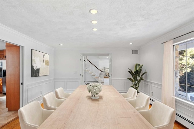 dining space with a baseboard radiator, recessed lighting, visible vents, a textured ceiling, and stairs