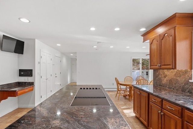 kitchen featuring dark stone counters, brown cabinetry, recessed lighting, and decorative backsplash