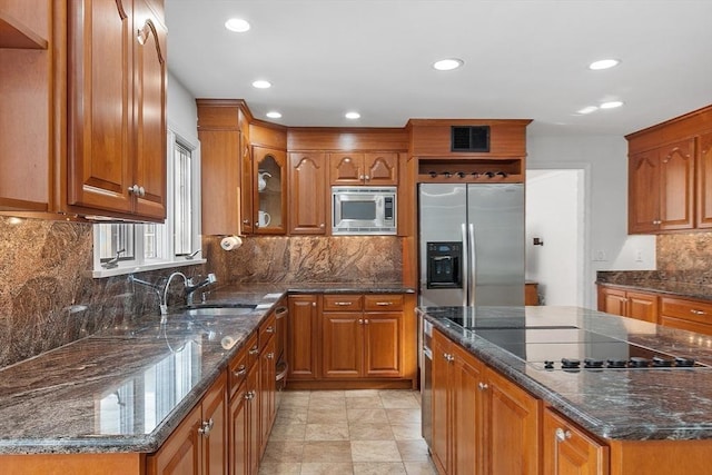 kitchen with stainless steel appliances, brown cabinets, and a sink